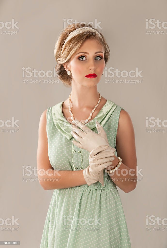 1950s-blonde-woman-in-green-dress-with-gloves-picture-id489349682